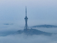 City buildings are seen in the clouds in the West Coast New Area of Qingdao, Shandong province, China, on October 26, 2024. (