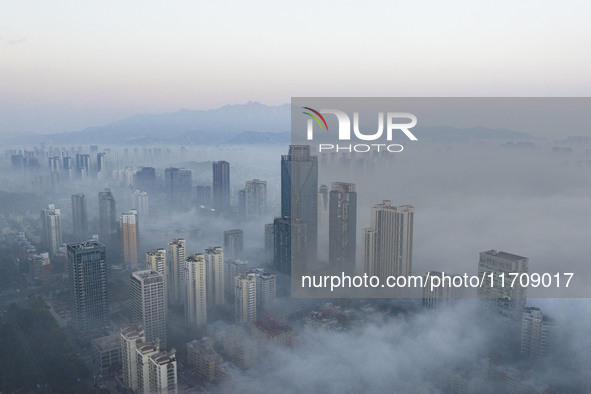 City buildings are seen in the clouds in the West Coast New Area of Qingdao, Shandong province, China, on October 26, 2024. 