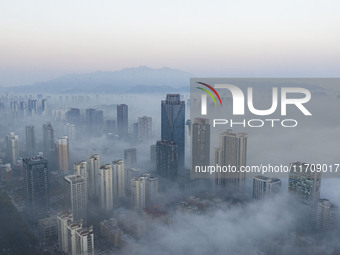 City buildings are seen in the clouds in the West Coast New Area of Qingdao, Shandong province, China, on October 26, 2024. (