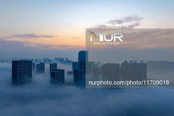 City buildings are seen in the clouds in the West Coast New Area of Qingdao, Shandong province, China, on October 26, 2024. 