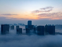 City buildings are seen in the clouds in the West Coast New Area of Qingdao, Shandong province, China, on October 26, 2024. (