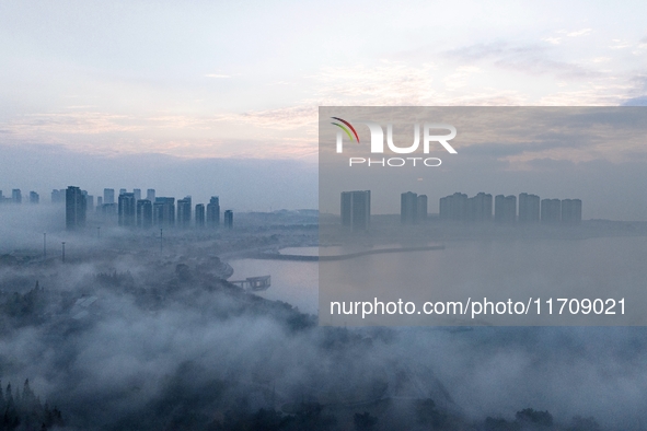 City buildings are seen in the clouds in the West Coast New Area of Qingdao, Shandong province, China, on October 26, 2024. 