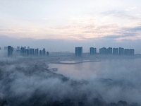 City buildings are seen in the clouds in the West Coast New Area of Qingdao, Shandong province, China, on October 26, 2024. (