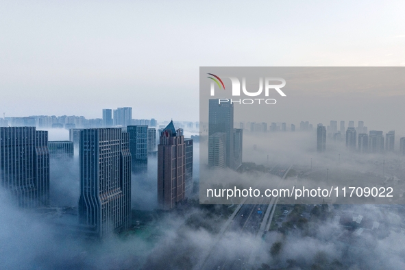 City buildings are seen in the clouds in the West Coast New Area of Qingdao, Shandong province, China, on October 26, 2024. 