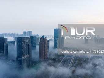 City buildings are seen in the clouds in the West Coast New Area of Qingdao, Shandong province, China, on October 26, 2024. (