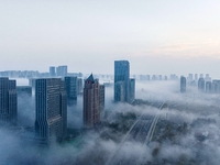 City buildings are seen in the clouds in the West Coast New Area of Qingdao, Shandong province, China, on October 26, 2024. (