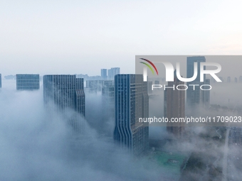 City buildings are seen in the clouds in the West Coast New Area of Qingdao, Shandong province, China, on October 26, 2024. (