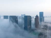 City buildings are seen in the clouds in the West Coast New Area of Qingdao, Shandong province, China, on October 26, 2024. (