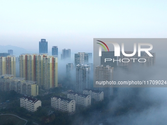 City buildings are seen in the clouds in the West Coast New Area of Qingdao, Shandong province, China, on October 26, 2024. (