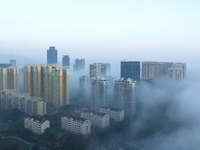 City buildings are seen in the clouds in the West Coast New Area of Qingdao, Shandong province, China, on October 26, 2024. (