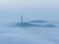 City buildings are seen in the clouds in the West Coast New Area of Qingdao, Shandong province, China, on October 26, 2024. (