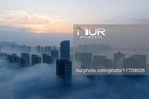 City buildings are seen in the clouds in the West Coast New Area of Qingdao, Shandong province, China, on October 26, 2024. 