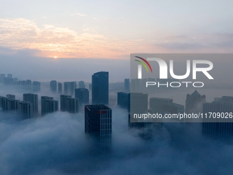 City buildings are seen in the clouds in the West Coast New Area of Qingdao, Shandong province, China, on October 26, 2024. (