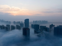 City buildings are seen in the clouds in the West Coast New Area of Qingdao, Shandong province, China, on October 26, 2024. (