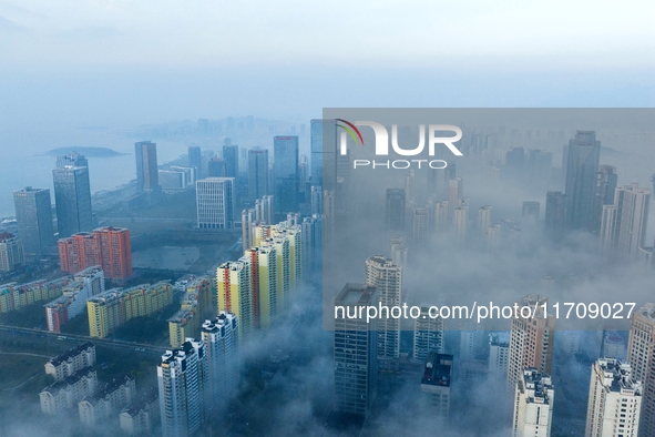 City buildings are seen in the clouds in the West Coast New Area of Qingdao, Shandong province, China, on October 26, 2024. 