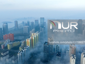 City buildings are seen in the clouds in the West Coast New Area of Qingdao, Shandong province, China, on October 26, 2024. (