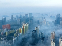 City buildings are seen in the clouds in the West Coast New Area of Qingdao, Shandong province, China, on October 26, 2024. (