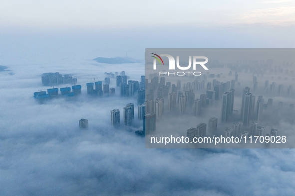 City buildings are seen in the clouds in the West Coast New Area of Qingdao, Shandong province, China, on October 26, 2024. 