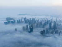 City buildings are seen in the clouds in the West Coast New Area of Qingdao, Shandong province, China, on October 26, 2024. (