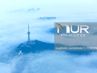 City buildings are seen in the clouds in the West Coast New Area of Qingdao, Shandong province, China, on October 26, 2024. (