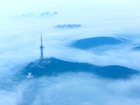 City buildings are seen in the clouds in the West Coast New Area of Qingdao, Shandong province, China, on October 26, 2024. (