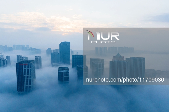 City buildings are seen in the clouds in the West Coast New Area of Qingdao, Shandong province, China, on October 26, 2024. 