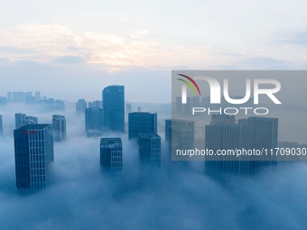 City buildings are seen in the clouds in the West Coast New Area of Qingdao, Shandong province, China, on October 26, 2024. (