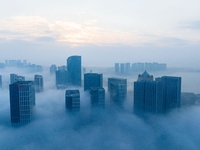 City buildings are seen in the clouds in the West Coast New Area of Qingdao, Shandong province, China, on October 26, 2024. (