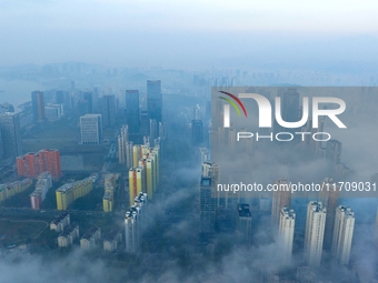 City buildings are seen in the clouds in the West Coast New Area of Qingdao, Shandong province, China, on October 26, 2024. (