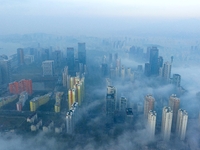 City buildings are seen in the clouds in the West Coast New Area of Qingdao, Shandong province, China, on October 26, 2024. (