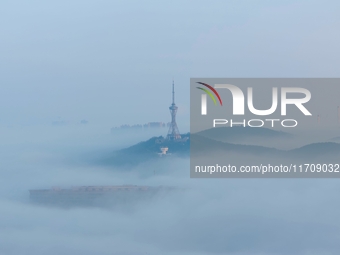 City buildings are seen in the clouds in the West Coast New Area of Qingdao, Shandong province, China, on October 26, 2024. (