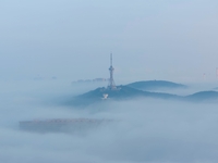 City buildings are seen in the clouds in the West Coast New Area of Qingdao, Shandong province, China, on October 26, 2024. (