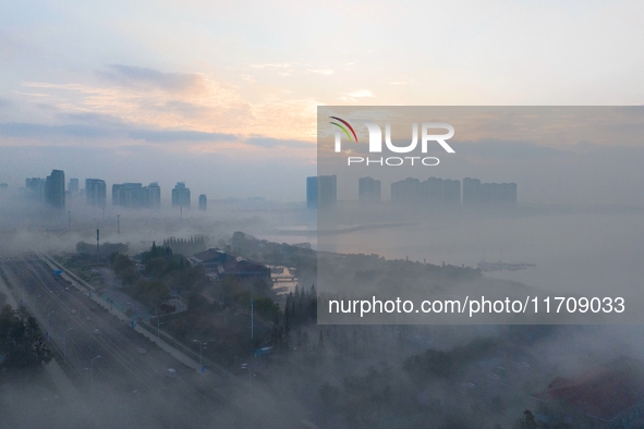 City buildings are seen in the clouds in the West Coast New Area of Qingdao, Shandong province, China, on October 26, 2024. 