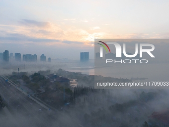 City buildings are seen in the clouds in the West Coast New Area of Qingdao, Shandong province, China, on October 26, 2024. (