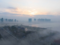 City buildings are seen in the clouds in the West Coast New Area of Qingdao, Shandong province, China, on October 26, 2024. (