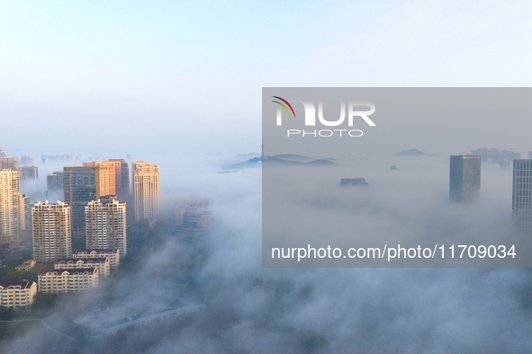 City buildings are seen in the clouds in the West Coast New Area of Qingdao, Shandong province, China, on October 26, 2024. 