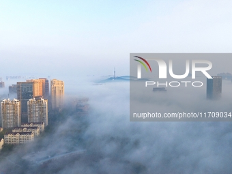 City buildings are seen in the clouds in the West Coast New Area of Qingdao, Shandong province, China, on October 26, 2024. (