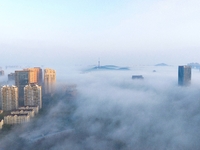 City buildings are seen in the clouds in the West Coast New Area of Qingdao, Shandong province, China, on October 26, 2024. (