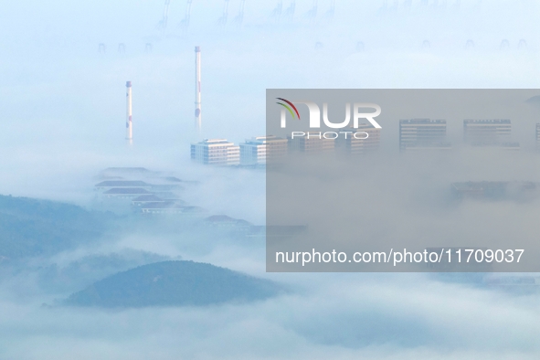 City buildings are seen in the clouds in the West Coast New Area of Qingdao, Shandong province, China, on October 26, 2024. 