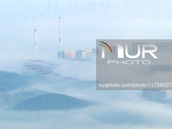 City buildings are seen in the clouds in the West Coast New Area of Qingdao, Shandong province, China, on October 26, 2024. (