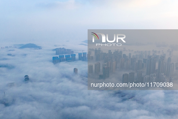 City buildings are seen in the clouds in the West Coast New Area of Qingdao, Shandong province, China, on October 26, 2024. 