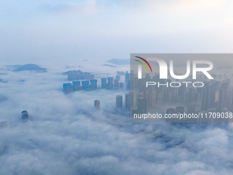 City buildings are seen in the clouds in the West Coast New Area of Qingdao, Shandong province, China, on October 26, 2024. (