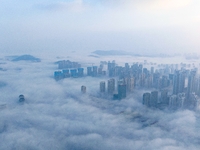 City buildings are seen in the clouds in the West Coast New Area of Qingdao, Shandong province, China, on October 26, 2024. (