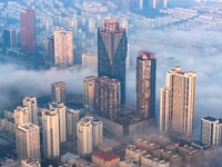 City buildings are seen in the clouds in the West Coast New Area of Qingdao, Shandong province, China, on October 26, 2024. (