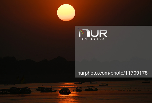 Visitors are silhouetted against the setting sun as they ride a boat during sunset at Sangam, the confluence of the rivers Ganges, Yamuna, a...