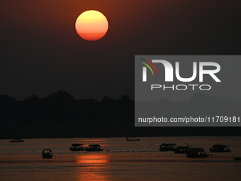 Visitors are silhouetted against the setting sun as they ride a boat during sunset at Sangam, the confluence of the rivers Ganges, Yamuna, a...