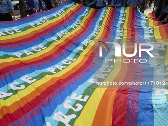 Thousands of people march through Bari, Italy, on October 26, 2024, with banners and flags during a peace rally titled ''Stop the wars, the...