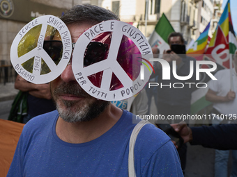 Thousands of people march through Bari, Italy, on October 26, 2024, with banners and flags during a peace rally titled ''Stop the wars, the...