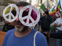 Thousands of people march through Bari, Italy, on October 26, 2024, with banners and flags during a peace rally titled ''Stop the wars, the...