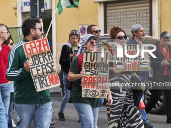 Thousands of people march through Bari, Italy, on October 26, 2024, with banners and flags during a peace rally titled ''Stop the wars, the...